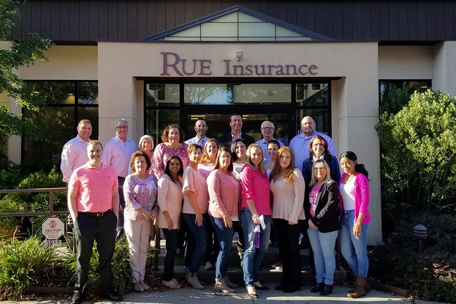 Community Involvement - Portrait of Rue Insurance Team Standing Outside Office Celebrating Breast Cancer Awareness Month