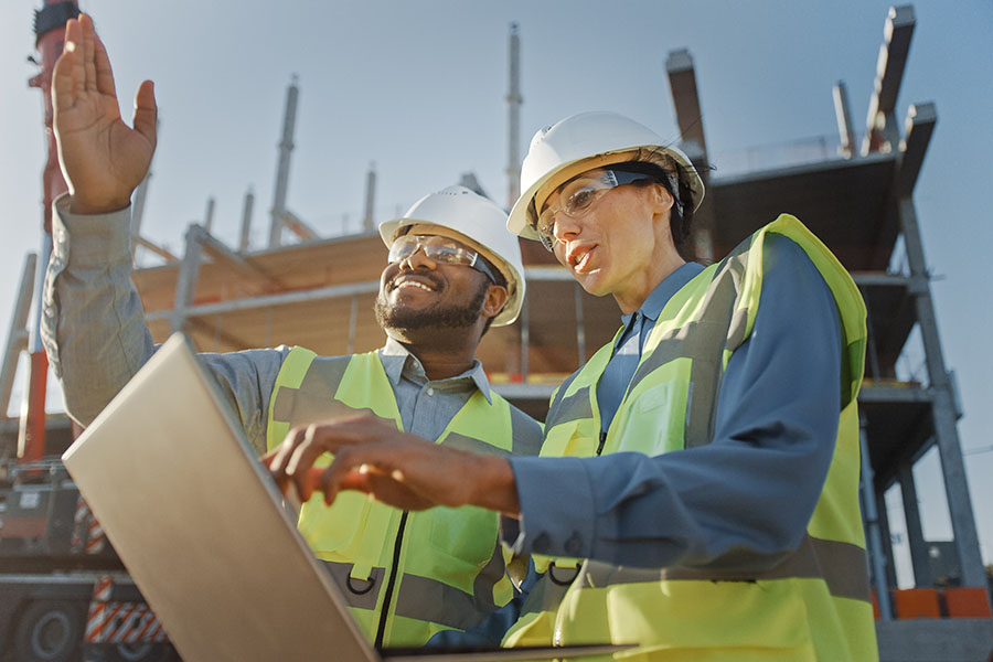 Specialized Small Business Insurance - View of Two Contractors Discussing Building Plans at Construction Jobsite
