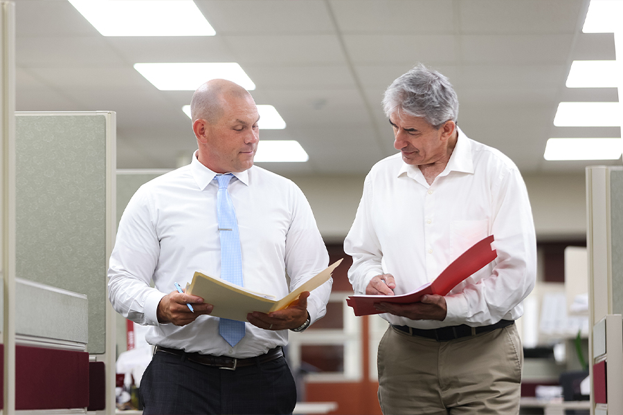 Surety Bonds - Two Male Workers at Rue Insurance Looking Over Some Folders